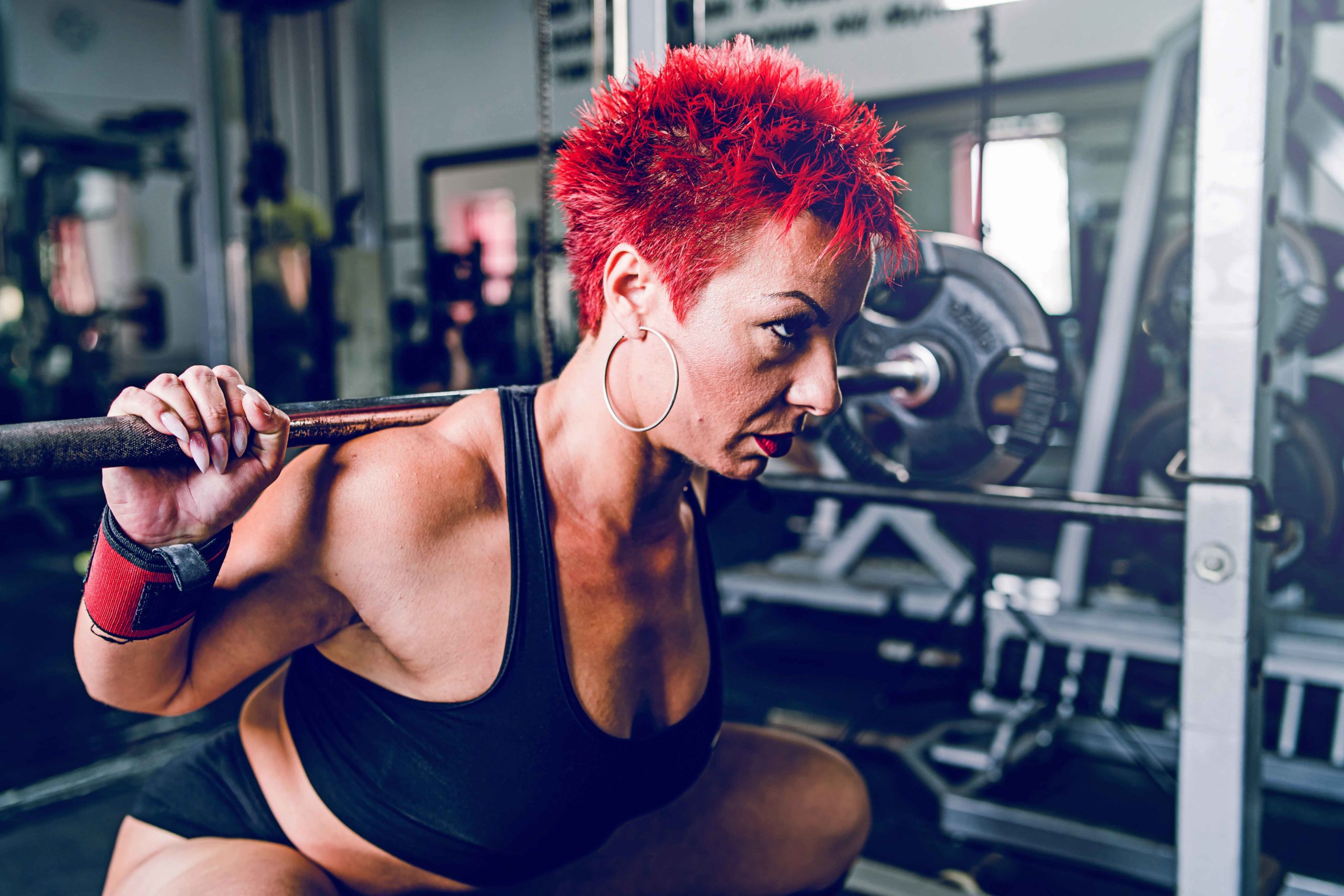 Close up on woman training at the gym Close up on Olympic weightlifting woman training at the gym and performing a dead squat
