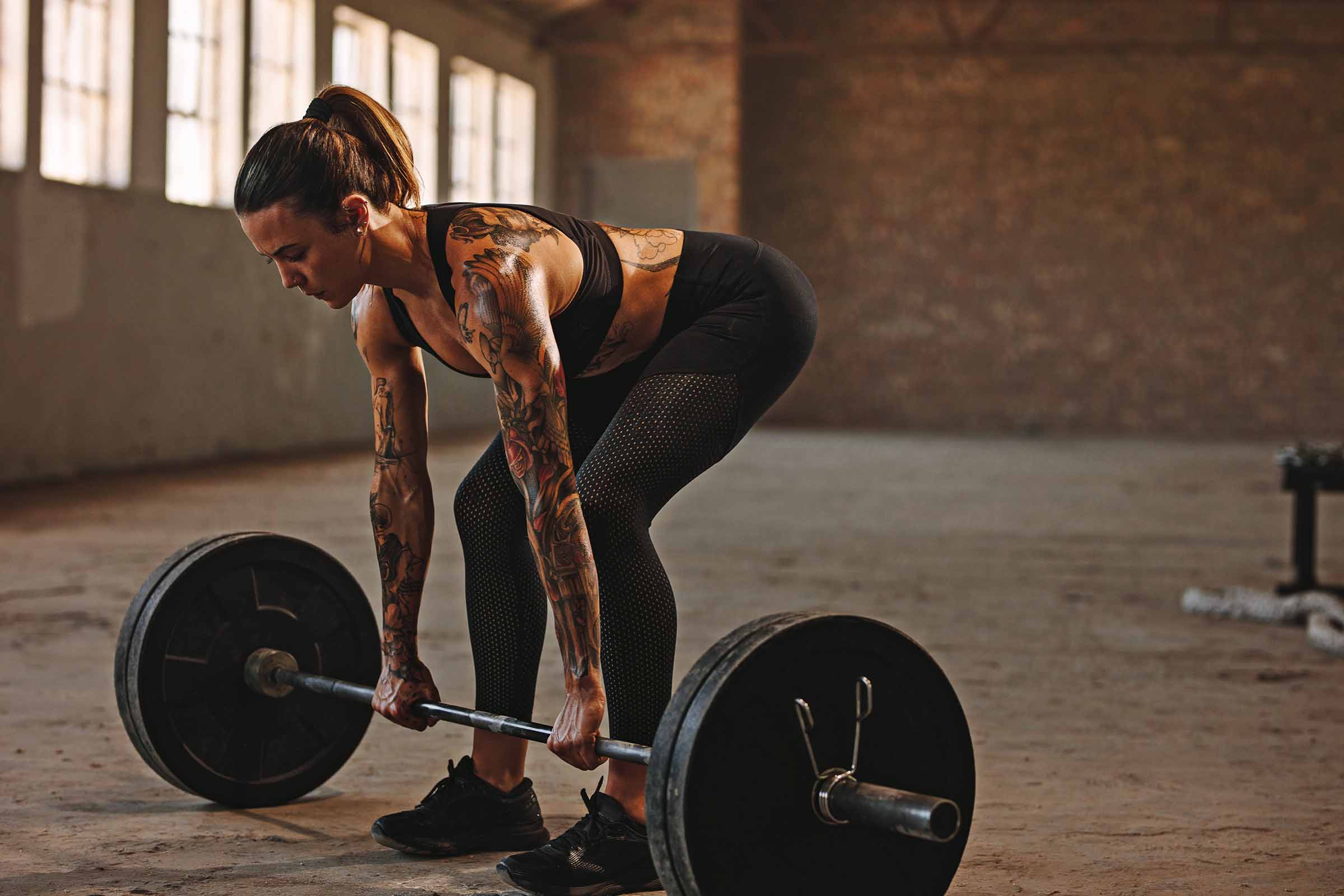 Learn to Deadlift Woman in gym doing deadlift