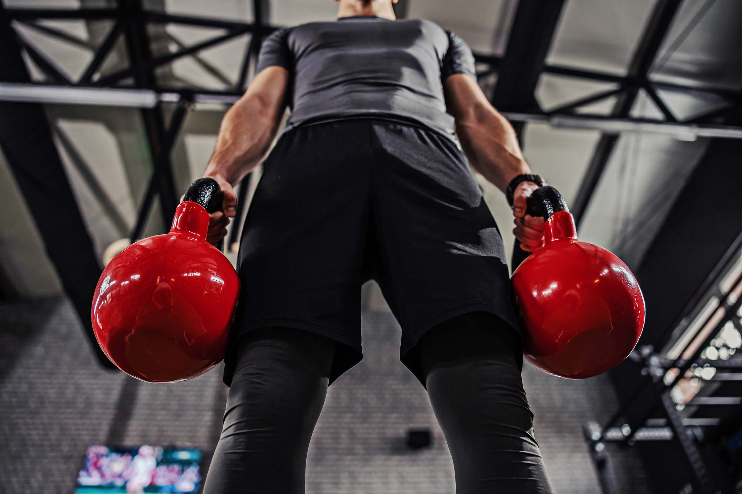 Portrait of a part of man's body holding a kettle bell with both strongman kettlebell farmer carry