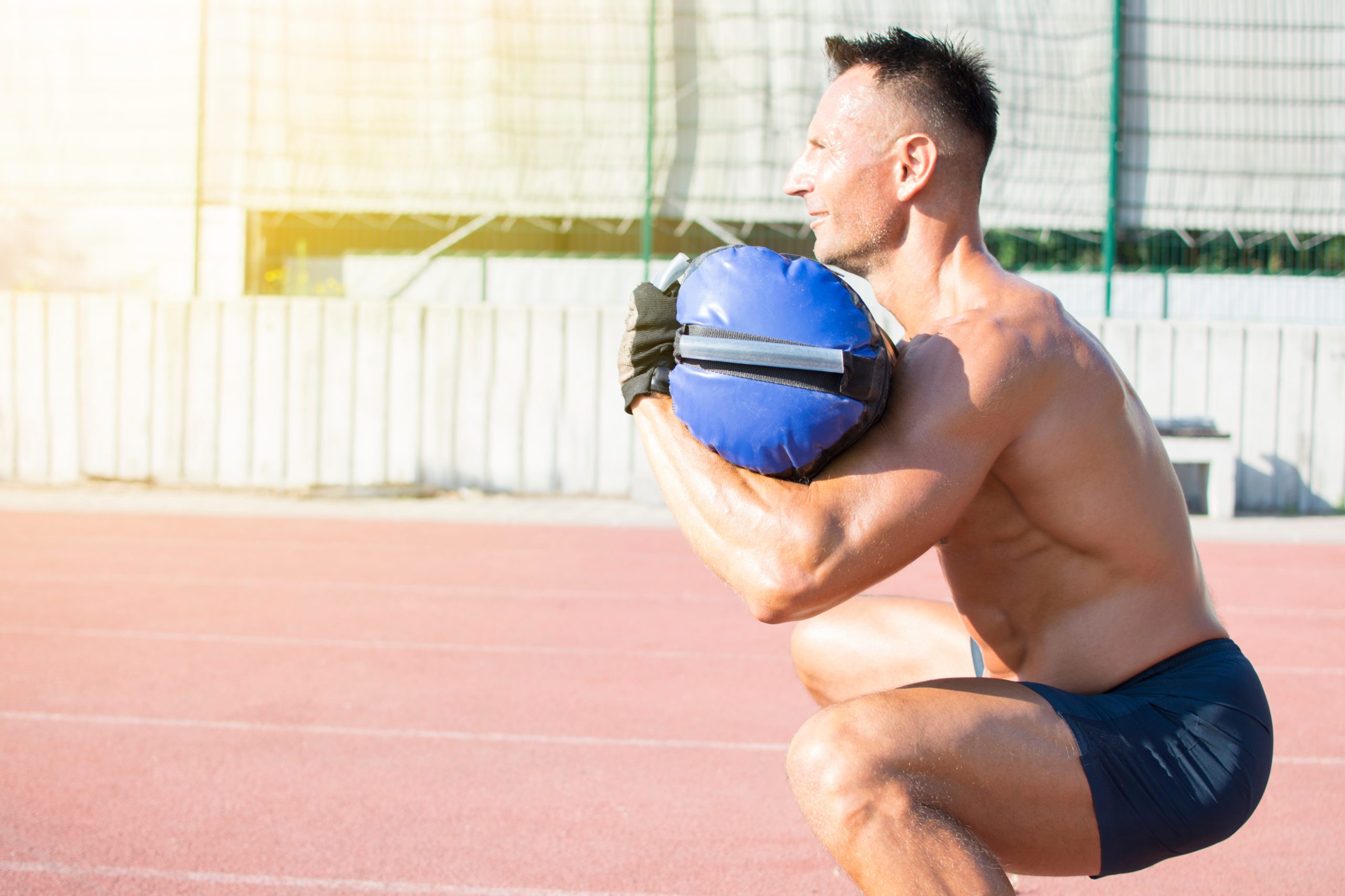 Handsome middle aged man working out on a running track. Healthy The Best Strength Training Split if You Have No Time