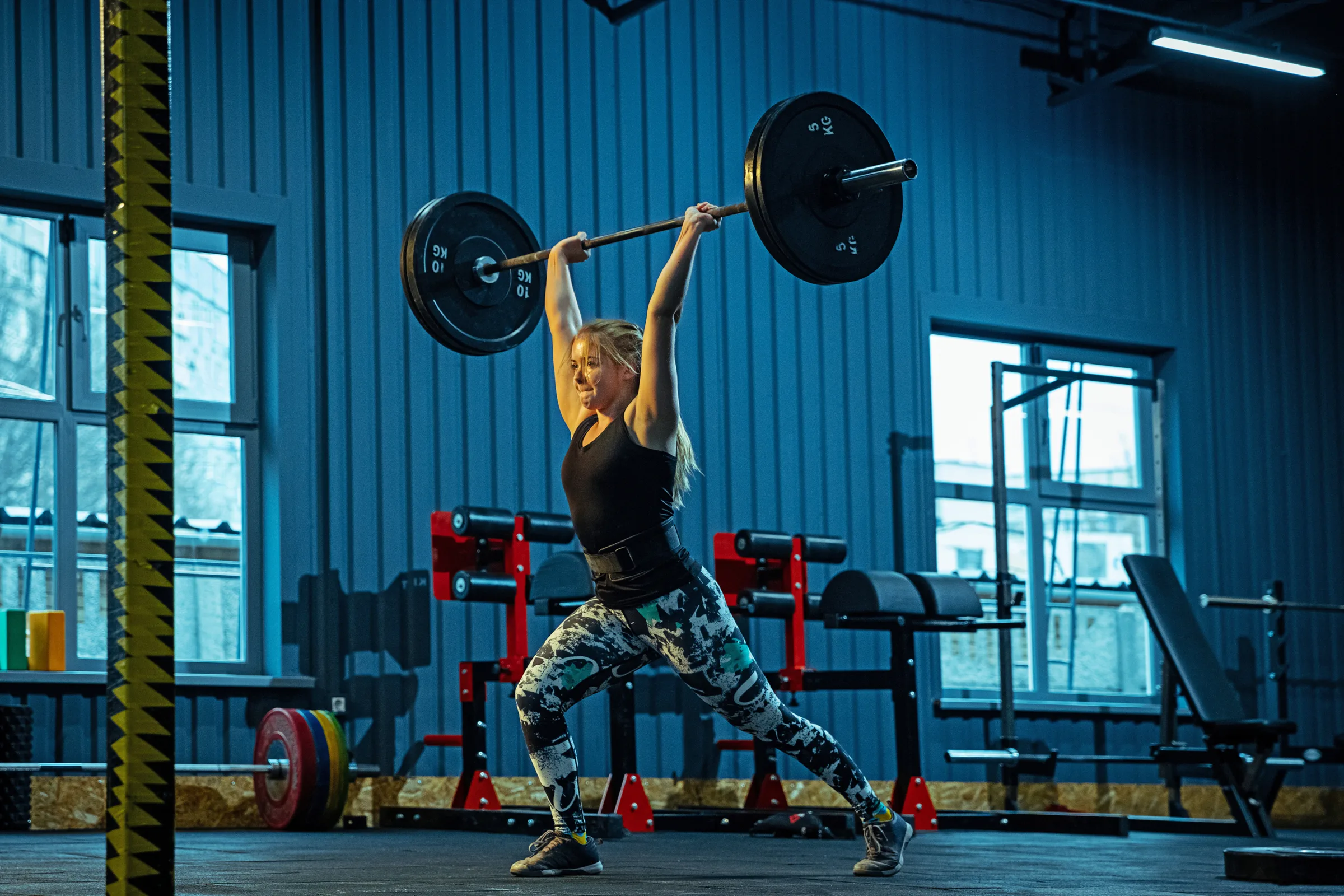 Caucasian teenage girl practicing in weightlifting in gym olympic weightlifting clean and jerk