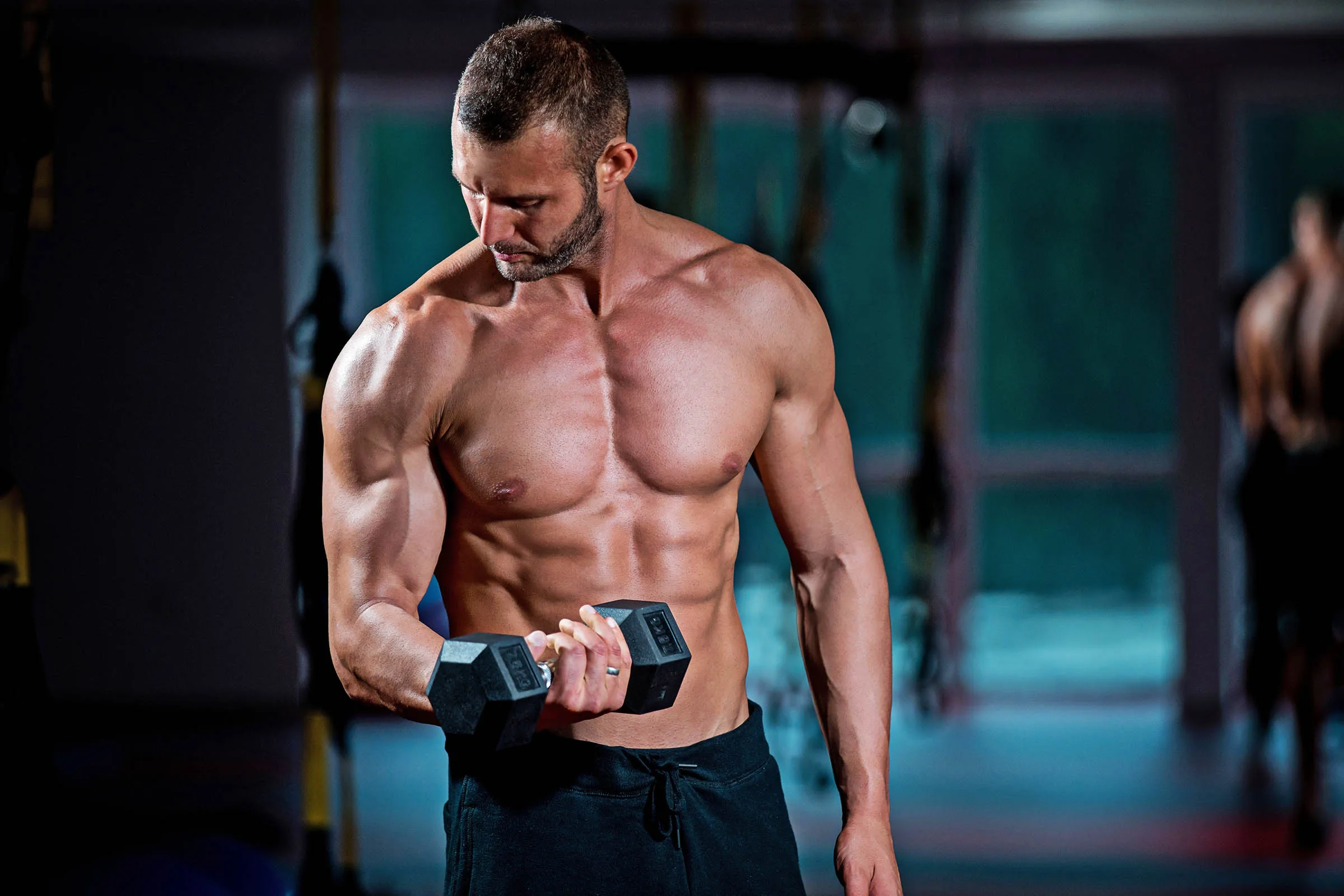 Build Muscle as a Vegan Athlete Muscular vegan athlete building muscle at the gym doing a bicep curl