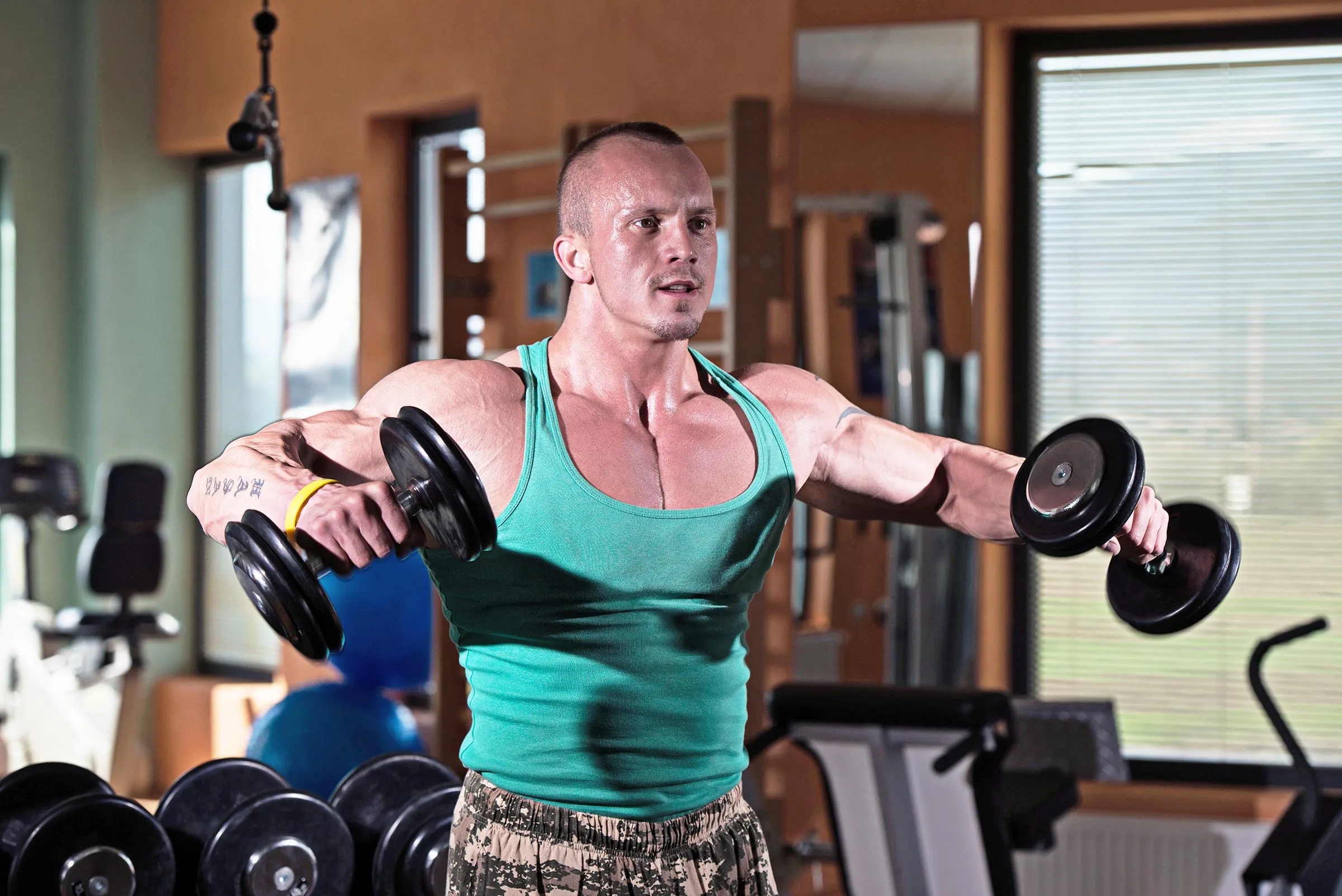 Bodybuilder Weight Lifting with Dumbbell lateral raise for building shoulder muscles