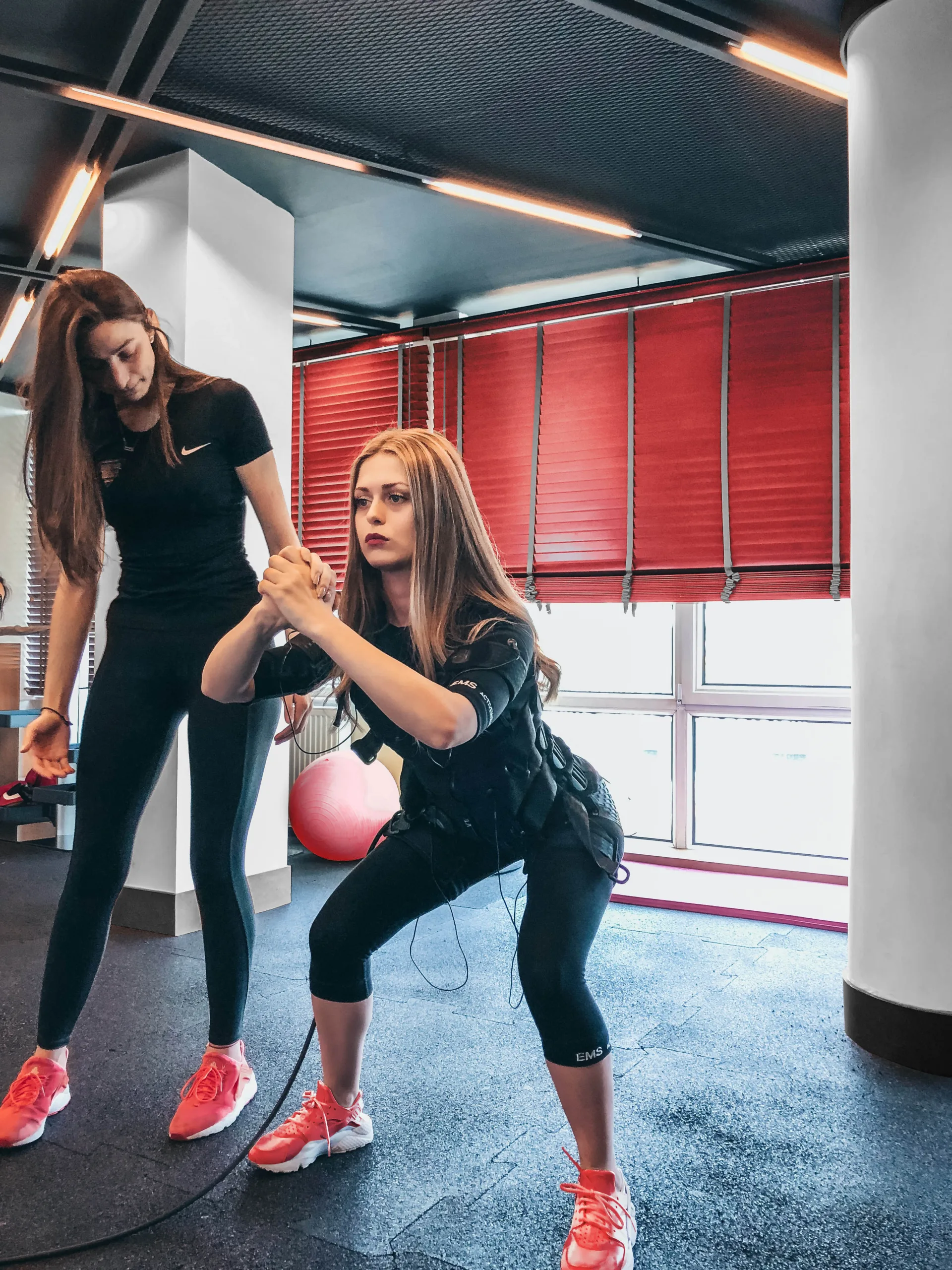 sule-makaroglu-PnUYkTFkOD0-unsplash_NR A personal trainer helping someone workout.